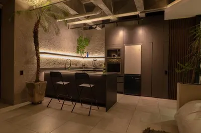 a kitchen with a island with two bar stools at Vive Pisoverde - a Loft with a green soul in Medellín