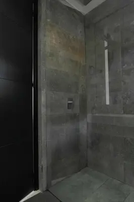 a bathroom with a shower with a glass door at Vive Pisoverde - a Loft with a green soul in Medellín