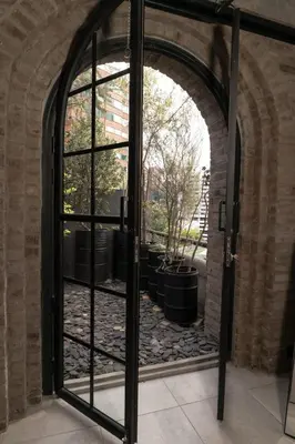 an open door to a patio with potted plants at Vive Pisoverde - a Loft with a green soul in Medellín