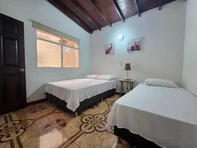 two beds in a room with a window at 5StarHomes - Casa privada cerca al Estadio y la 70 in Medellín
