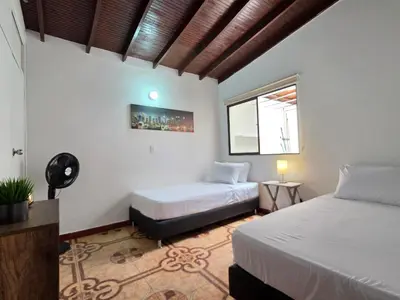 a bedroom with two beds and a window at 5StarHomes - Casa privada cerca al Estadio y la 70 in Medellín