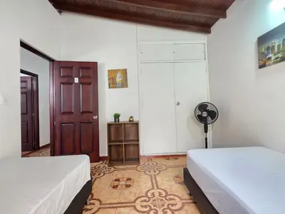 a bedroom with two beds and a door and a fan at 5StarHomes - Casa privada cerca al Estadio y la 70 in Medellín