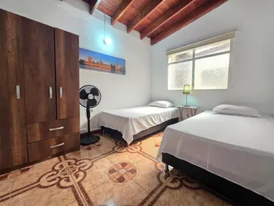 a bedroom with two twin beds and a window at 5StarHomes - Casa privada cerca al Estadio y la 70 in Medellín