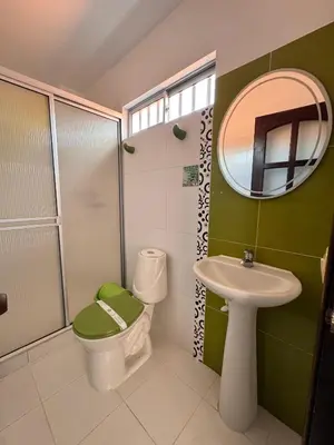 a bathroom with a toilet and a sink and a mirror at Hotel Premium BISS in Supía