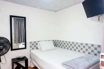 a small bedroom with a bed and a mirror at Hotel Familiar in Medellín