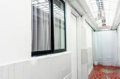 a hallway with a window in a white room at Hotel Familiar in Medellín