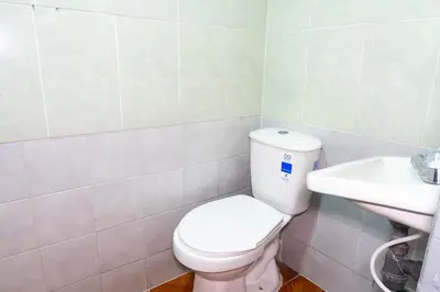 a bathroom with a white toilet and a sink at Hotel Familiar in Medellín
