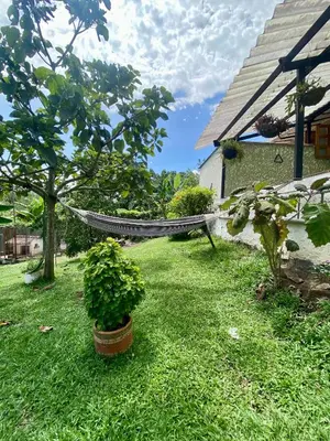a hammock in a yard next to a house at Finca Villa Juan Pablo in Anserma