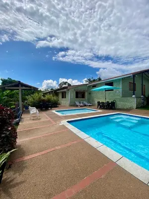 a swimming pool in front of a house at Finca Villa Juan Pablo in Anserma