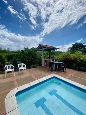 a swimming pool with a picnic table and a table and chairs at Finca Villa Juan Pablo in Anserma