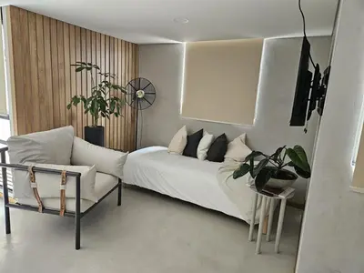 a bedroom with a bed and a chair and a clock at 2402 Luxury apartment in Sabaneta in Sabaneta