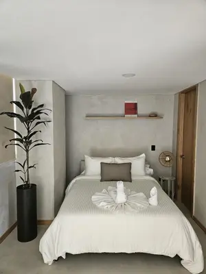 a bedroom with a large white bed and a plant at 2402 Luxury apartment in Sabaneta in Sabaneta