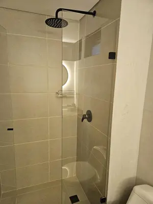 a shower with a glass door in a bathroom at 2402 Luxury apartment in Sabaneta in Sabaneta