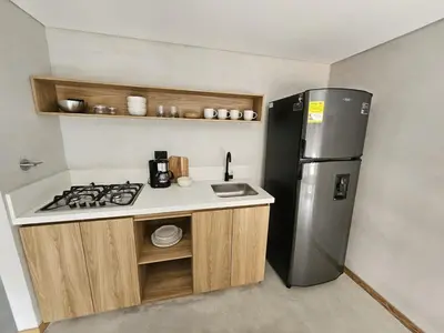 a small kitchen with a stove and a refrigerator at 2402 Luxury apartment in Sabaneta in Sabaneta