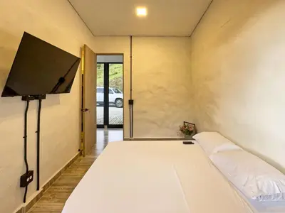a bedroom with a bed with a flat screen tv at 3BR Esmeralda Country Home Santa Elena in Santa Elena