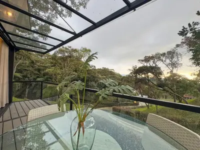 a glass table with a plant in a vase on a balcony at 3BR Esmeralda Country Home Santa Elena in Santa Elena