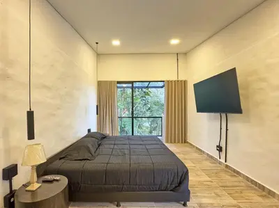a bedroom with a bed and a flat screen tv at 3BR Esmeralda Country Home Santa Elena in Santa Elena