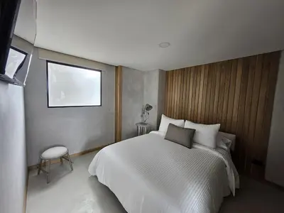 a bedroom with a large white bed and a window at 2404 Luxurious apartment with Jacuzzi in Sabaneta