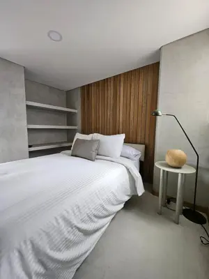 a bedroom with a large white bed and a lamp at 2406 Luxurious apartment with jacuzzi in Sabaneta