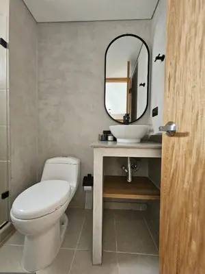 a bathroom with a toilet and a sink and a mirror at 2406 Luxurious apartment with jacuzzi in Sabaneta