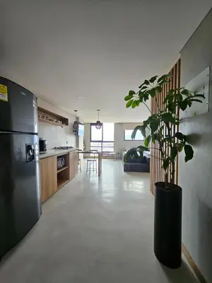 a kitchen and living room with a refrigerator and a plant at 2406 Luxurious apartment with jacuzzi in Sabaneta