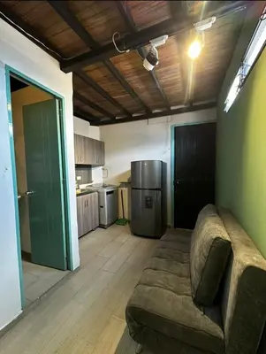 a living room with a couch and a kitchen at Aptos en la naturaleza in Medellín