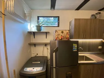 a small kitchen with a refrigerator and a sink at Aptos en la naturaleza in Medellín