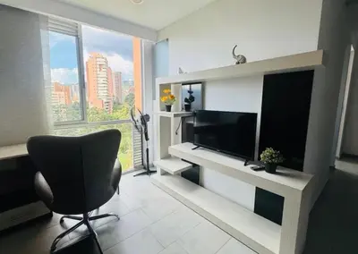 a living room with a television and a chair at Apartaestudio de 2 habitaciones cerca a provenza y el tesoro in Medellín