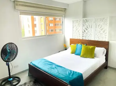a bedroom with a bed with a fan and a window at Apartaestudio de 2 habitaciones cerca a provenza y el tesoro in Medellín