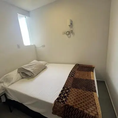 a small bedroom with a bed with a blanket on it at Apartaestudio de 2 habitaciones cerca a provenza y el tesoro in Medellín