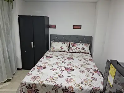 a bedroom with a bed with a floral bedspread at Confortable Apartamento Parque Caldas Manizales in Manizales
