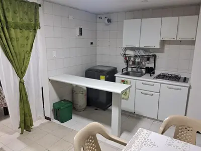 a small kitchen with a table and a counter top at Confortable Apartamento Parque Caldas Manizales in Manizales