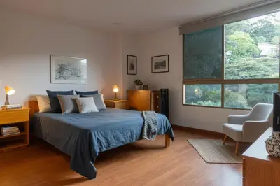 a bedroom with a bed and a large window at Espacio en Medellin, Ideal para tu estilo de vida moderno, estrátegico y cómodo in Medellín