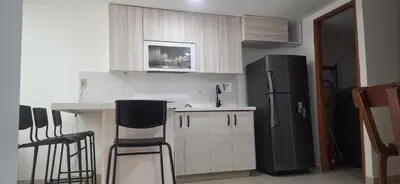 a kitchen with white cabinets and a black refrigerator at Espacio en Medellin, Ideal para tu estilo de vida moderno, estrátegico y cómodo in Medellín
