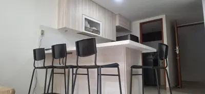 a kitchen with three bar stools in front of a counter at Espacio en Medellin, Ideal para tu estilo de vida moderno, estrátegico y cómodo in Medellín