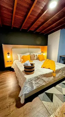 a bedroom with a large bed with yellow pillows at Suite con jacuzzi en El Poblado in Medellín