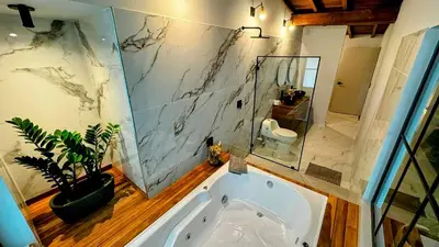 a bathroom with a large tub and a potted plant at Suite con jacuzzi en El Poblado in Medellín