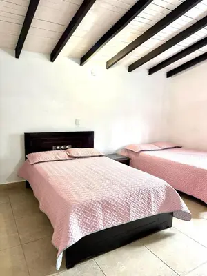 two beds in a bedroom with pink comforter at House near Marial stone and old Peñol replica in Horizonte