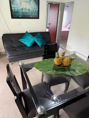 a living room with a table with a bowl of fruit on it at House near Marial stone and old Peñol replica in Horizonte