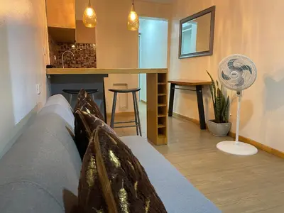 a living room with a couch and a kitchen at cozy Apartamento de 1alcoba los molinos CERCA a laurles in Medellín