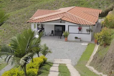 a small white house with a red roof at Espectacular vista a la represa el peñol in La Pradera