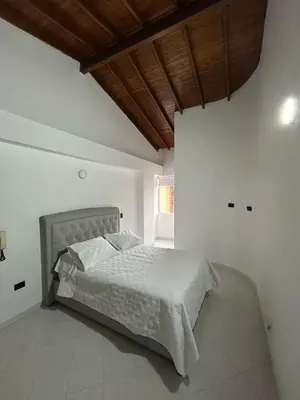 a white bedroom with a bed with a wooden ceiling at Hermoso apartamento para disfrutar su estadía in Medellín
