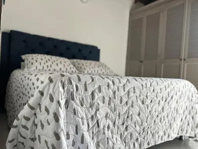 a bedroom with a bed with a white comforter at Hermoso apartamento para disfrutar su estadía in Medellín