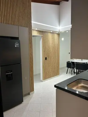 a kitchen with a black refrigerator and a table at Hermoso apartamento para disfrutar su estadía in Medellín