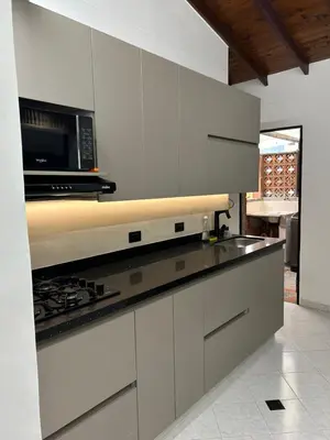a kitchen with white cabinets and a microwave at Hermoso apartamento para disfrutar su estadía in Medellín