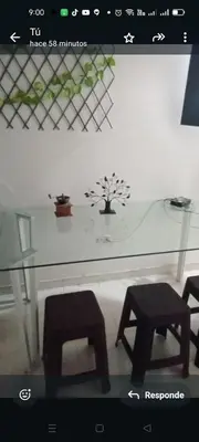 a glass table with two chairs and a plant on it at En el mejor punto de Medellin in Medellín