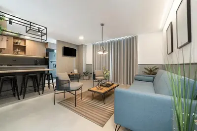 a living room with a blue couch and a kitchen at Apt in el Poblado, walkable area with parking 215 in Medellín