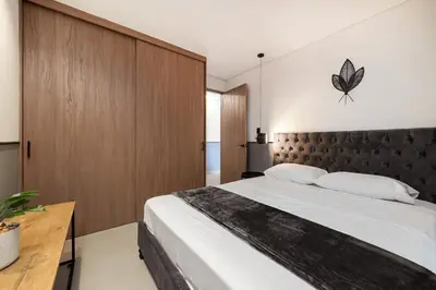 a bedroom with a large bed with a butterfly on the wall at Apt in el Poblado, walkable area with parking 215 in Medellín