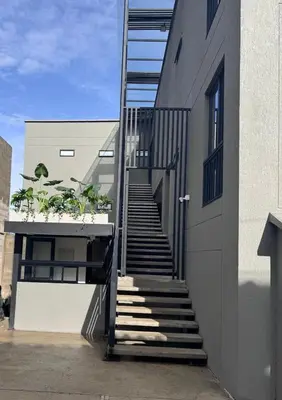 a staircase leading up to a building with potted plants at Apt in el Poblado, walkable area with parking 215 in Medellín