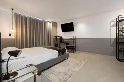 a bedroom with a bed and a desk and a television at Apt in el Poblado, walkable area with parking 215 in Medellín